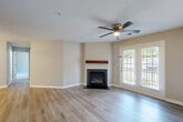 Located at 315 Flint Hill Rd in Fort Mill, SC, this well-appointed 2-bedroom, 2-bathroom single-story home offers a thoughtfully designed layout across a comfortable footprint. The open living room serves as the heart of the home, featuring a classic fireplace with a wood mantel, light hardwood-style flooring, a ceiling fan, and bright French doors that invite natural light and provide outdoor access. The kitchen is well-equipped with warm wood cabinetry, granite countertops, stainless steel appliances including a built-in microwave, range, and dishwasher, and a peninsula with a double sink — ideal for both cooking and casual dining. Both bedrooms are carpeted and include ceiling fans and windows that bring in natural light and outdoor views. The generously sized primary bedroom includes a walk-in closet with wire shelving for ample storage. The bathrooms are clean and functional, with one featuring a full tub-shower combination and light hardwood-style flooring. Neutral tones throughout the home create a cohesive, move-in-ready atmosphere that is both practical and inviting.