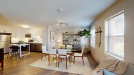 Located at 20 Day St in Norwalk, CT, this thoughtfully designed single-floor residence offers a seamless blend of modern aesthetics and functional living. The open-concept layout connects the kitchen, dining, and living areas, creating a bright and cohesive space bathed in natural light from multiple windows throughout.

The kitchen is a standout feature, outfitted with stainless steel appliances, two-tone cabinetry combining crisp white upper cabinets and rich dark lower cabinets, a subway tile backsplash, and a compact island with bar seating — ideal for casual dining or meal prep.

The dining area accommodates a full-sized glass table and flows naturally into the living room, which offers generous space for seating arrangements and is grounded by warm hardwood-style flooring found throughout the home.

A dedicated home office provides a quiet, well-lit workspace, complete with a window view. The bedrooms are comfortably sized, each featuring ample closet storage and natural light. Two bathrooms serve the home — one a full bath with a tub/shower combination and tall cabinetry, and the other a clean, simply appointed half bath.

An in-unit laundry area with a full-size washer and dryer adds everyday convenience. The overall ambiance is warm, modern, and move-in ready.