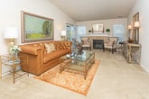 Located at 4100 Heron Springs Blvd in Lake Orion, Michigan, this thoughtfully designed single-floor residence offers a cohesive blend of comfort and modern style throughout its well-organized layout. The living room serves as a welcoming centerpiece, featuring plush carpeting, a tiled fireplace flanked by windows that invite natural light, and ample space for relaxed gatherings. Adjacent to the living area, the dining room accommodates a full-sized table and chairs beneath an elegant pendant light, making it ideal for entertaining. The kitchen is outfitted with dark espresso cabinetry, granite countertops, stainless steel appliances including a microwave, range, and refrigerator, and durable wood-look tile flooring that extends into the hallway. The primary bedroom is generously proportioned with soft carpet, large windows, and access to a private en-suite bathroom featuring dark vanity cabinetry with granite counters, tile flooring, and a glass-enclosed shower. A second full bathroom includes a soaking tub with tile surround and coordinating tile floors. Additional rooms include a comfortable secondary bedroom with ample natural light and a flexible den or home office space with carpet and an open connection to the dining area. A cozy family room rounds out the interior with a sectional sofa and warm, inviting ambiance.