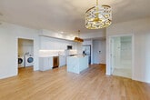 Located at 1602 S Federal Hwy in Boynton Beach, FL, this well-appointed 3-bedroom, 3-bathroom residence offers a thoughtfully designed open-concept layout across a single floor. Light wood-look flooring flows throughout the main living areas, lending a warm, contemporary feel. The kitchen serves as the heart of the home, showcasing crisp white cabinetry with gold hardware, a striking marble-veined waterfall island, stainless steel appliances, and a suite of bold gold pendant lights that add a luxurious touch. The kitchen opens seamlessly into the living room, which is brightened by a ceiling fan and large sliding glass doors leading to a private balcony with outdoor views. Each of the three bedrooms features plush carpeting, generous closet space with built-in shelving, and sliding glass doors that connect to the balcony, filling the rooms with natural light. The three bathrooms are finished in neutral tones with marble-style tile surrounds and soaking tub-shower combinations. A dedicated in-unit laundry area houses a full-size washer and dryer. The overall ambiance is clean, modern, and move-in ready, reflecting a cohesive design palette of whites, neutrals, and gold accents throughout.
