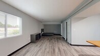 This one-bedroom, two-bathroom unit at 2084 S Hamilton Rd in Columbus, Ohio offers a functional and well-appointed single-floor layout. Throughout the unit, durable light-toned luxury vinyl plank flooring and neutral gray walls create a clean, modern aesthetic complemented by textured ceilings and dark baseboards.

The living room is generously proportioned, featuring a large window that fills the space with natural light and views of the surrounding greenery. The kitchen is fully equipped with warm-toned wood cabinetry, light countertops, and a full suite of black appliances including a refrigerator, gas range, microwave, and dishwasher. A built-in breakfast bar with an attached table provides a convenient dining area directly adjacent to the kitchen.

The bedroom offers a comfortable footprint with recessed lighting and sliding barn-style doors providing access to the space. Two closets offer ample storage throughout the unit. The primary bathroom features an extended wood-toned vanity with a granite-style countertop, a large mirror, and generous drawer storage. The second bathroom includes a full tub and shower combination with accessibility grab bars. A dedicated utility room and additional closet space round out the practical layout of this well-designed unit.