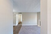 Located at 203 Eastdale Rd S in Montgomery, Alabama, this 2-bedroom, 2-bathroom single-floor residence offers a practical and comfortable layout. The combined living and dining area is a highlight of the home, featuring plush carpeting, a textured ceiling, and a tile-surround wood-burning fireplace. Sliding glass doors flood the living space with natural light and provide access to an outdoor area. The dining space transitions to rich hardwood-style flooring and is accented by a pendant light fixture. The kitchen features white cabinetry and ample counter space. Both bedrooms are carpeted and well-proportioned, each equipped with a ceiling fan, a sliding-door closet, and windows with blinds that invite natural light. The primary bedroom offers generous space for furnishings. Both bathrooms are identically appointed with full tub-shower combinations featuring white tile surrounds and chrome fixtures. Additional practical features include a dedicated laundry area and four closets throughout, providing abundant storage. Neutral gray-toned walls and consistent finishes create a clean, cohesive aesthetic throughout the home.