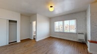 Located in the vibrant Koreatown neighborhood of Los Angeles, this single-floor unit at 260 S Mariposa Ave blends classic character with modern updates. Throughout the space, warm hardwood-style flooring provides a cohesive and inviting foundation.

The living area is bright and open, featuring white walls, a vintage-style ceiling light fixture, and a front entry door that welcomes natural light. A half-wall partition subtly separates the living space from the kitchen, maintaining an open feel while defining each area.

The kitchen is a standout feature, offering white cabinetry, rich wood-tone countertops, a stainless steel sink, and a striking teal mosaic tile backsplash. A black gas range with overhead ventilation hood completes the functional and stylish cooking space.

The bedroom showcases a distinctive painted brick accent wall beneath large windows fitted with horizontal blinds, offering neighborhood views and ample natural light. A closet and direct access to the bathroom add convenience.

The bathroom is clean and contemporary, finished with large-format gray wall tiles surrounding a soaking bathtub with shower, a pedestal sink, and dark slate-toned floor tiles. A window above the tub allows for natural ventilation and light. The overall ambiance of the space is bright, functional, and full of character.