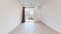 Located at 122 Liberty Ln in Nashville, TN, this single-story home offers a well-designed layout with two bedrooms, two bathrooms, a living room, kitchen, and two closets. The interior is finished with light hardwood flooring throughout, crisp white walls, and recessed lighting, creating a clean, contemporary atmosphere.

The living room is a standout feature, offering generous proportions and a sliding glass door that opens to an outdoor balcony view, flooding the space with natural light. The kitchen is efficiently designed with white shaker-style cabinetry, light countertops, and a full suite of stainless steel appliances, including a range, over-the-range microwave, and side-by-side refrigerator.

The primary bedroom is spaciously sized and connects to a dedicated bathroom featuring a walk-in tiled shower with neutral gray tile surround. The second bedroom offers a bright window with outdoor views. The second bathroom includes a tiled tub-shower combo and white vanity. Both closets are equipped with wire shelving systems, providing practical, organized storage throughout the home.