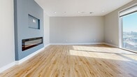 This contemporary 3-bedroom, 1-bathroom apartment in Philadelphia offers 1,330 square feet of meticulously designed living space. The open-concept floor plan maximizes the use of space, creating a seamless flow between the living areas. Floor-to-ceiling windows in the main living area provide breathtaking panoramic views of the city skyline, flooding the space with natural light.

The kitchen is a chef's dream, featuring sleek white cabinetry, high-end stainless steel appliances, and a striking marble waterfall island that doubles as a breakfast bar. The living room is anchored by a modern fireplace insert, adding both warmth and style to the space.

All three bedrooms boast hardwood floors and large windows, with the primary bedroom measuring a spacious 190 square feet. The bathroom is a luxurious retreat, showcasing a glass-enclosed shower with elegant marble-look tiling.

Throughout the apartment, recessed lighting and neutral tones create a bright, airy ambiance. Built-in storage solutions, including a walk-in closet with custom shelving, provide ample space for organization. The apartment's single floor layout ensures easy accessibility, while the staircase suggests potential access to building amenities or a rooftop terrace.

This urban oasis seamlessly blends functionality with high-end finishes, offering a sophisticated living experience in the heart of Philadelphia.