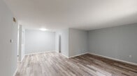 This single-story, two-bedroom, one-and-a-half-bath unit in Baton Rouge, Louisiana offers a clean, move-in-ready interior defined by a consistent neutral color palette and wood-look luxury vinyl plank flooring throughout. The open living area is generously proportioned, with light gray walls, white baseboards, and ceiling-mounted lighting that contribute to a bright, airy atmosphere. A sliding glass door with vertical blinds allows natural light to fill the space and provides access to the outdoors.

The kitchen is a functional highlight, featuring gray shaker-style cabinetry extending to the upper walls, light countertops, and black appliances including a refrigerator, gas range, and under-cabinet range hood. A stainless steel sink completes the space, which continues the same wood-look flooring found throughout the unit.

Both bedrooms are well-sized, with one offering a window fitted with horizontal blinds for natural light and privacy. The primary bedroom includes a walk-in closet with built-in shelving and direct access to a private half bath. A full bathroom serves the remaining bedroom and features a walk-in shower with white surround. Additional storage is provided by a large louvered bifold closet in the hallway, enhancing the overall practicality of this thoughtfully laid-out home.
