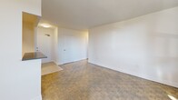 Located at 28 Helene St N in Mississauga's Port Credit neighbourhood, this third-floor unit offers a practical and well-organized layout across a compact but efficiently utilized floor plan. The living room is a standout feature, bathed in natural light through large floor-to-ceiling sliding glass doors that open directly onto a private balcony. The balcony extends the living space outdoors, offering open views of the surrounding cityscape and neighbouring buildings. Parquet wood flooring runs throughout the living areas, lending warmth and character to the neutral, white-painted interiors.

The kitchen is accessed through a dedicated opening off the main living area and features modern white cabinetry, a light subway tile backsplash, white tile flooring, and stainless steel appliances including a refrigerator and dishwasher. The bedroom is a comfortable, well-lit room with a window overlooking neighbouring buildings, parquet flooring, baseboard heating, and mirrored sliding closet doors. The bathroom is finished with large-format neutral tiles surrounding a full soaker tub with overhead shower, complemented by a mirrored medicine cabinet. A hallway connects all rooms, providing a logical and functional flow throughout the unit.