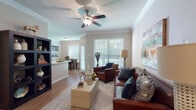 This single-story residence offers a thoughtfully designed layout that seamlessly connects the main living spaces. The living room serves as the heart of the home, featuring crown molding, wood-style flooring, and a ceiling fan overhead. Large windows fitted with blinds invite abundant natural light, while open sightlines extend into the dining area and kitchen, enhancing the sense of spaciousness throughout.

The dedicated dining area accommodates a full-sized table and benefits from its own window, maintaining a bright and welcoming atmosphere. Adjacent to the dining space, the kitchen is equipped with stainless steel appliances, including a range, microwave, and refrigerator, complemented by light wood cabinetry and light-toned countertops. Wood-style flooring continues through this area, adding visual continuity.

The bedroom is a comfortable retreat featuring plush carpeting, a ceiling fan, a large window with ample natural light, and direct access to a walk-in closet. The full bathroom presents an elongated layout with a dual-sink vanity featuring light wood cabinetry, a soaking tub with shower, wood-style flooring, and generous closet storage, providing both functionality and comfort.
