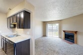 Located at 3625 N 104th Ave in Omaha, Nebraska, this two-bedroom, one-bathroom residence offers a well-organized single-floor layout designed for comfortable everyday living. The open living room is a standout space, featuring plush carpeting, a wood-mantled fireplace, and a sliding glass door that opens onto a private balcony with outdoor views of the surrounding neighborhood. Natural light fills the room, creating a warm and inviting atmosphere.

The galley-style kitchen is efficiently laid out with rich dark espresso cabinetry lining both walls, light-toned countertops, a double-basin sink, and black appliances including a range and dishwasher. Wood-look flooring runs through the kitchen and dining area, providing a clean contrast to the carpeted living spaces.

Both bedrooms are carpeted and receive natural light through blinded windows. The primary bedroom offers a dedicated walk-in closet with multiple hanging rods and shelving, providing ample storage. The second bedroom includes a standard closet with bifold doors. The full bathroom is finished with wood-look flooring, a tub-shower combo, and a vanity with a mirror.

A textured ceiling is consistent throughout the unit, and neutral wall tones create a cohesive, move-in-ready aesthetic throughout the entire space.