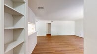 Located on Chimney Rock Road in Houston, TX, this single-floor residence offers a well-organized layout with two bedrooms, three bathrooms, and a combined kitchen and living area. The open-plan living and dining space is finished with warm hardwood-style flooring and features a pass-through kitchen counter with white brick accents, creating a welcoming and connected atmosphere. The kitchen is equipped with white cabinetry, speckled countertops, stainless steel appliances including a dishwasher and refrigerator, and a window that brings in natural light and outdoor views. The living area extends generously, offering ample room for comfortable furnishings. Both bedrooms feature plush carpeting, ceiling fans with integrated lighting, and neutral walls that create a calm, restful environment. The primary bedroom is spacious and includes a walk-in closet with built-in shelving. Two additional closets provide practical storage throughout the home. The three bathrooms are clean and functional, with at least one featuring a full bathtub with a shower, wood-style flooring, and a window for natural ventilation. A hallway connects the private areas of the home, completing a functional and comfortable floor plan.