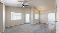 Located at 2855 E Broadway Rd in Mesa, AZ, this one-bedroom, one-bathroom residence offers a well-organized single-floor layout designed for comfortable everyday living. The living room is an inviting, open space highlighted by vaulted ceilings and a ceiling fan, creating an airy atmosphere. Large windows fitted with blinds allow natural light to fill the room, while a combination of wood-look hard flooring and plush carpeting defines distinct areas of the space. The bedroom is generously proportioned, featuring soft carpeting, a ceiling fan, and windows that provide natural light and views of surrounding greenery. Two closets offer ample storage throughout the unit. The bedroom connects conveniently to the full bathroom, which is outfitted with wood-look tile flooring, a single vanity with a countertop sink, and a tiled shower-tub combination. The neutral, warm beige tones carried throughout the unit create a cohesive and calm aesthetic. The layout also includes a kitchen area visible in the floorplan, with a pass-through counter and adjacent laundry hookups, adding functional utility to the space. Overall, this unit presents a practical and comfortable living environment in Mesa, Arizona.