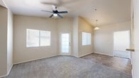 Located at 2855 E Broadway Rd in Mesa, AZ, this one-bedroom, one-bathroom residence offers a well-organized single-floor layout designed for comfortable everyday living. The living room is an inviting, open space highlighted by vaulted ceilings and a ceiling fan, creating an airy atmosphere. Large windows fitted with blinds allow natural light to fill the room, while a combination of wood-look hard flooring and plush carpeting defines distinct areas of the space. The bedroom is generously proportioned, featuring soft carpeting, a ceiling fan, and windows that provide natural light and views of surrounding greenery. Two closets offer ample storage throughout the unit. The bedroom connects conveniently to the full bathroom, which is outfitted with wood-look tile flooring, a single vanity with a countertop sink, and a tiled shower-tub combination. The neutral, warm beige tones carried throughout the unit create a cohesive and calm aesthetic. The layout also includes a kitchen area visible in the floorplan, with a pass-through counter and adjacent laundry hookups, adding functional utility to the space. Overall, this unit presents a practical and comfortable living environment in Mesa, Arizona.