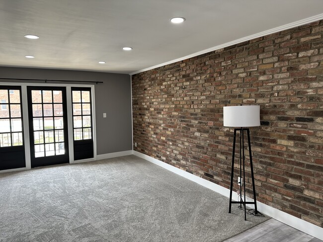 Living room with brick wall, newly painted and new carpet - 1220 Chatham Park Dr