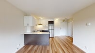 Located at 625 Rue Milton in the heart of Montréal's Milton-Parc neighbourhood, this one-bedroom, one-bathroom unit offers a clean, contemporary design across a single floor. Light wood laminate flooring runs throughout the living spaces, creating a bright and cohesive feel.

The open-concept kitchen is a standout feature, equipped with a two-tone cabinetry scheme pairing crisp white upper cabinets with dark wood-finish lower cabinets. A white quartz-style countertop extends into a peninsula that separates the kitchen from the living area, providing additional prep space and a casual seating option. Stainless steel appliances — including a full-size refrigerator and range — complete the functional layout, while a white tile backsplash adds a clean, polished finish.

The living area is generously proportioned and benefits from a large window overlooking the urban neighbourhood, allowing natural light to fill the room. The bedroom is a quiet, well-sized space featuring neutral walls, the same warm wood flooring, and a sliding-door closet providing ample storage.

The bathroom is finished with light tile flooring, a dark wood vanity with a white countertop and under-mount sink, a full soaking tub, and glass shelving for storage. The overall aesthetic throughout is modern, neutral, and move-in ready.
