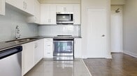 Located at 130 Raglan Ave in Toronto's vibrant Cedarvale neighbourhood, this one-bedroom, one-bathroom unit offers an efficiently designed layout across a single floor. The parquet hardwood flooring runs throughout the living areas and bedroom, lending a warm, classic character to the space.

The kitchen is well-appointed with crisp white shaker-style cabinetry, dark countertops, a light subway tile backsplash, and a full suite of stainless steel appliances including a refrigerator, stove, and over-the-range microwave. Glossy ceramic floor tiles and ample cabinet storage make this a practical and attractive cooking space.

The living room is open and bright, with neutral walls and the same rich parquet flooring, creating a cohesive feel throughout. A baseboard heating unit and a window allow for natural light and comfortable temperature control.

The bedroom is a comfortable size, featuring a mirrored sliding-door closet that reflects natural light from the window, enhancing the sense of space. The parquet flooring continues here, maintaining the unit's consistent aesthetic.

The bathroom is finished with full white subway tile surrounds, a pedestal-style vanity, a mirror, and a soaker tub with shower — clean and functional in design.

A hallway connects all rooms efficiently, completing this well-organized and move-in ready unit.