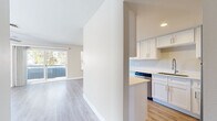 Located at 1525 E Baseline Rd in Tempe, Arizona, this single-story 2-bedroom, 2-bathroom residence offers a clean, modern aesthetic with a thoughtfully designed layout. Light wood-style flooring runs throughout the home, complementing the neutral warm-beige tones on every wall and creating a cohesive, airy feel.

The living room is a standout space, bathed in natural light streaming through large sliding glass doors that open to an outdoor balcony area with views of surrounding greenery. A ceiling fan adds comfort and character to the room. The adjacent kitchen is well-equipped with white shaker-style cabinetry, light countertops, stainless steel appliances including a refrigerator, range, microwave, and dishwasher, and a galley-style layout that maximizes functionality.

The primary bedroom offers a comfortable footprint with a ceiling fan, a window with natural light, and access to hallway areas. The second bedroom is equally bright, also featuring a ceiling fan and window. Both bathrooms are finished with white vanity cabinetry, light countertops, wood-style flooring, and tub-shower combinations. A dedicated closet provides additional storage. Two hallways connect the rooms efficiently, rounding out this well-organized and move-in-ready home.