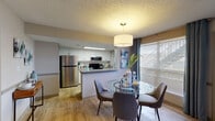 Located at 11990 Beach Blvd in Jacksonville, Florida, this single-floor residence offers a thoughtfully designed layout that balances comfort and functionality. Light wood-look flooring flows throughout the main living areas, complemented by neutral-toned walls and textured ceilings fitted with ceiling fans in each room.

The living room is a welcoming space, featuring large windows with blinds that allow natural light to fill the room. A wall-mounted TV, decorative chair rail molding, and coordinated furnishings give the area a polished, contemporary feel.

Adjacent to the living room, the dining area is positioned near a generously sized window, creating a bright setting for meals. A stylish pendant light anchors the space above the dining table, with direct sightlines into the kitchen.

The kitchen is well-equipped with white cabinetry, granite-style countertops, stainless steel appliances including a refrigerator, microwave, and range, and a skylight that adds additional brightness to the galley-style layout.

Both bedrooms are comfortably sized, each featuring ceiling fans, ample natural light from windows, and access to closet space. One bedroom showcases a bold accent wall in navy blue, while the primary bedroom features a softer blue-gray palette.

The bathroom is cleanly finished with a granite-top vanity, white cabinetry, and a tub-shower combination.