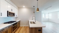 This single-story, 2-bedroom, 2-bathroom residence at 7109 E McDowell Rd in Scottsdale, Arizona offers a well-designed, modern living space with clean lines and contemporary finishes throughout. The open-concept kitchen serves as a central highlight, featuring white upper cabinetry with matte black hardware, warm wood-toned lower cabinets, and a large island with quartz countertops and an undermount stainless steel sink. A professional-style spring faucet, gas range, stainless steel appliances, and stylish pendant lighting complete the kitchen's functional and aesthetic appeal. Light wood-tone flooring flows through the main living areas, enhancing the bright, airy atmosphere.

Both bedrooms are carpeted and receive natural light through large windows with horizontal blinds, offering views of the surrounding Scottsdale landscape. One bedroom includes a ceiling fan. The two bathrooms are finished with quartz vanity countertops, warm wood cabinetry, LED-backlit mirrors, and walk-in showers with glass enclosures, delivering a clean, spa-inspired feel. Recessed lighting throughout maintains a consistent, modern ambiance, making this Scottsdale residence a well-appointed and comfortable living space.