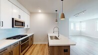 This single-story, 2-bedroom, 2-bathroom residence at 7109 E McDowell Rd in Scottsdale, Arizona offers a well-designed, modern living space with clean lines and contemporary finishes throughout. The open-concept kitchen serves as a central highlight, featuring white upper cabinetry with matte black hardware, warm wood-toned lower cabinets, and a large island with quartz countertops and an undermount stainless steel sink. A professional-style spring faucet, gas range, stainless steel appliances, and stylish pendant lighting complete the kitchen's functional and aesthetic appeal. Light wood-tone flooring flows through the main living areas, enhancing the bright, airy atmosphere.

Both bedrooms are carpeted and receive natural light through large windows with horizontal blinds, offering views of the surrounding Scottsdale landscape. One bedroom includes a ceiling fan. The two bathrooms are finished with quartz vanity countertops, warm wood cabinetry, LED-backlit mirrors, and walk-in showers with glass enclosures, delivering a clean, spa-inspired feel. Recessed lighting throughout maintains a consistent, modern ambiance, making this Scottsdale residence a well-appointed and comfortable living space.