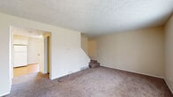 Located at 735 Marlan Ave. in Reynoldsburg, Ohio, this multi-level home spans three floors, offering a well-organized layout with comfortable living spaces throughout. The main level features a spacious living room with warm, neutral-toned carpet, textured ceilings, and a staircase connecting to the upper level. Adjacent to the living area is a bright dining room with hardwood flooring, a pendant light fixture, and sliding glass doors with vertical blinds that open to an outdoor patio, allowing generous natural light to fill the space. The kitchen is efficiently designed with white cabinetry, dark laminate countertops, hardwood flooring, and white appliances including a range, dishwasher, and refrigerator. A full bathroom on this level includes a tub-shower combination, hardwood flooring, and a wall mirror. The upper level contains multiple carpeted bedrooms, each with windows that bring in natural light and closet access. Neutral tones and textured ceilings are consistent throughout. The lower level features an unfinished basement with concrete block walls, a concrete floor, exposed wood beam ceiling, and a small window — offering considerable potential for storage or future development. The home provides a practical and adaptable living environment across all three floors.