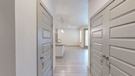 This well-designed 2-bedroom, 2-bathroom residence in Denver, CO offers a thoughtful single-floor layout with modern finishes throughout. The open-concept kitchen and living area serves as the heart of the home, featuring a large central island, dual-tone cabinetry with white upper and rich dark lower cabinets, a classic subway tile backsplash, stainless steel appliances including a refrigerator, range, and microwave, and stylish pendant lighting. Light wood-style flooring flows throughout the main living areas, adding a clean, contemporary feel. The primary bedroom is a comfortable retreat, complete with a ceiling fan and access to a well-appointed en-suite bathroom. The primary bath offers both a soaking tub and a glass-enclosed shower, tile surround, a vanity with undermount sink, and direct access to a walk-in closet with built-in shelving and hanging rods. The second bedroom features plush carpet, a ceiling fan, and a bright window with natural light. The second bathroom includes a glass-enclosed shower, tile surround, and a matching vanity. Both bedrooms are served by dedicated closets with organized storage. The living area opens to a private outdoor space via glass French doors, allowing abundant natural light to fill the room.