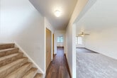 Located at 1300 Hillside Rd in Albion, Michigan, this three-bedroom, two-bathroom home spans three floors, offering a well-organized and functional layout. The main level features a welcoming hallway with hardwood-style flooring that flows toward the living room, which is finished with plush carpeting, a ceiling fan, and a large window fitted with vertical blinds that allow ample natural light. The kitchen is equipped with warm oak cabinetry, a double sink, white appliances including a range and refrigerator, and a window overlooking the outdoors. An adjacent dining area completes the main living space. The bedrooms are carpeted and each include ceiling fans and generous closet space, with several rooms featuring sliding or hinged wood-panel closet doors. The two bathrooms are finished with wood-tone vanities, countertop sinks, and hardwood-style flooring; the full bathroom includes a tub-shower combination. A utility basement provides additional functional space, housing the water heater, a utility sink, and exposed overhead systems, with a painted concrete floor and windows for ventilation. With six closets distributed throughout, storage is plentiful across all levels of this practical Albion home.