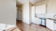 Located at 1912 11th St in Wichita Falls, TX, this one-bedroom, one-bathroom unit offers a well-designed single-floor layout that maximizes every square foot of its compact footprint. Warm hardwood-style flooring flows throughout the space, complemented by neutral wall tones and drop-panel ceilings fitted with ceiling fans, creating a bright and comfortable atmosphere.

The kitchen is a standout feature, outfitted with crisp white cabinetry, granite-style countertops, a subway tile backsplash, and a full suite of stainless steel appliances including a refrigerator, range, microwave, and dishwasher. The open sight lines from the kitchen into the hallway lend a connected, efficient feel to the layout.

The bedroom is generously proportioned, bathed in natural light through a large bank of windows dressed with vertical blinds, and fitted with a ceiling fan for year-round comfort. A dedicated closet with built-in shelving provides practical storage. The hallway leads seamlessly between rooms, maintaining a logical and comfortable flow.

The bathroom features floor-to-ceiling neutral tile surrounding a full soaking tub and shower combination, accented with brushed nickel fixtures and built-in shelving niches, delivering a clean, polished finish. Overall, this unit presents a thoughtfully updated interior with functional design and modern finishes throughout.