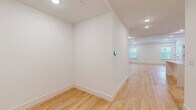 Located at 325-327 Union Blvd in Totowa, NJ, this thoughtfully designed 1-bedroom, 2-bathroom residence offers generous single-floor living with a clean, modern aesthetic throughout. Light-toned hardwood floors span the entire unit, complementing the crisp white walls and recessed lighting that create a bright, welcoming atmosphere.

The open kitchen/living area is a standout feature, showcasing white shaker cabinetry with matte black hardware, quartz countertops, a deep undermount sink with a black faucet, and stainless steel GE appliances including a gas range and dishwasher. The adjacent living room is well-proportioned and filled with natural light from multiple windows.

The spacious primary bedroom offers a serene retreat with natural views through large windows and direct access to a generously sized walk-in closet outfitted with built-in shelving and hanging rods. Two full bathrooms serve the unit: one features a sleek frameless glass sliding shower with floor-to-ceiling white tile and large-format gray stone-look flooring, while the second includes a white vanity and open shelving. Both bathrooms carry consistent matte black hardware throughout. Recessed lighting, smart thermostat controls, and a well-organized layout round out this polished, move-in-ready home.