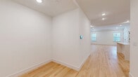 Located at 325-327 Union Blvd in Totowa, NJ, this thoughtfully designed 1-bedroom, 2-bathroom residence offers generous single-floor living with a clean, modern aesthetic throughout. Light-toned hardwood floors span the entire unit, complementing the crisp white walls and recessed lighting that create a bright, welcoming atmosphere.

The open kitchen/living area is a standout feature, showcasing white shaker cabinetry with matte black hardware, quartz countertops, a deep undermount sink with a black faucet, and stainless steel GE appliances including a gas range and dishwasher. The adjacent living room is well-proportioned and filled with natural light from multiple windows.

The spacious primary bedroom offers a serene retreat with natural views through large windows and direct access to a generously sized walk-in closet outfitted with built-in shelving and hanging rods. Two full bathrooms serve the unit: one features a sleek frameless glass sliding shower with floor-to-ceiling white tile and large-format gray stone-look flooring, while the second includes a white vanity and open shelving. Both bathrooms carry consistent matte black hardware throughout. Recessed lighting, smart thermostat controls, and a well-organized layout round out this polished, move-in-ready home.