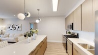 This contemporary single-floor residence in Jackson, NJ offers a thoughtfully designed open-concept layout with modern finishes throughout. The kitchen serves as a central highlight, featuring flat-front light wood cabinetry, crisp white quartz countertops, a large center island with seating, subway tile backsplash, and stainless steel appliances including a gas range and French door refrigerator. Stylish globe pendant lights add a modern touch overhead, while light wood-tone flooring flows seamlessly throughout the space.

The living area is bright and inviting, with recessed lighting, a large window dressed with sheer curtains, and ample room for comfortable furnishings. The bedrooms are serene and well-proportioned, offering natural light through generous windows, walk-in closet access, and a neutral palette that creates a calm atmosphere.

Two bathrooms maintain the home's clean aesthetic — one features a soaking tub and a floating wood-toned vanity with a large mirror, while the second offers a glass-enclosed walk-in shower with tile surround and a matching floating vanity. A dedicated in-unit laundry area with a full-size washer and dryer adds everyday convenience. The overall design balances modern sophistication with functional living.