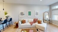 This 710 square foot apartment in Windsor, CT offers a masterful blend of modern design and functional living. The open-concept floor plan creates a seamless flow between the living area, kitchen, and bedroom. The living room is anchored by a plush white sectional sofa, complemented by modern art prints and a floor lamp, creating an inviting atmosphere. 

The kitchen boasts crisp white cabinetry, stainless steel appliances, and a subway tile backsplash, offering both style and functionality. A central island with a sink provides additional workspace and casual dining options. The bedroom features a comfortable queen-sized bed with a metal frame, ample natural light from the window, and thoughtful decor touches.

The bathroom showcases a clean, contemporary design with neutral-toned tiles, a wooden vanity, and a glass-enclosed shower. Throughout the apartment, light wood flooring adds warmth and continuity. Climate control is ensured by a wall-mounted air conditioning unit.

Additional amenities include a flat-screen TV in the living area, strategically placed lighting fixtures, and decorative elements that enhance the overall modern aesthetic. The apartment's efficient layout and stylish design make it an ideal urban dwelling for those seeking a contemporary living space in Windsor.