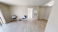 Located at 611 Lead Ave SW in Albuquerque, New Mexico, this one-bedroom, one-bathroom residence offers a well-organized single-floor layout designed to maximize every square foot. The living area features light wood-style luxury vinyl flooring and neutral beige walls that create a clean, bright atmosphere. A sliding glass door floods the space with natural light and provides direct access to the outdoors, offering views of the surrounding neighborhood. The galley-style kitchen is efficiently arranged with white cabinetry lining both walls, stainless steel appliances including a refrigerator and range, a sink with countertop workspace, and overhead lighting — a functional setup well-suited for everyday cooking. The bedroom is carpeted for comfort and includes a ceiling fan with integrated lighting, a window with blinds for natural light control, and access to a dedicated walk-in closet outfitted with multiple hanging rods and shelving. The bathroom is finished with wood-style flooring, a granite-topped vanity with white cabinetry, and a full tub-shower combination with white tile surround and brushed nickel fixtures. Consistent neutral tones and clean finishes throughout give the space a cohesive, move-in-ready feel.