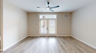 Located on Greenfield Road in Lancaster, PA, this well-appointed one-bedroom, one-bathroom unit offers a thoughtfully designed single-floor layout with modern finishes throughout. The open-concept kitchen and living area serves as the heart of the home, featuring flat-front white cabinetry extending to the ceiling, white subway tile backsplash, stainless steel appliances including a gas range, over-the-range microwave, and a bottom-freezer refrigerator. Light wood-look luxury vinyl plank flooring runs throughout the main living areas, adding warmth and cohesion to the space. The living room is bright and airy, highlighted by glass French doors with a transom window above that invite natural light and provide outdoor access. A sleek ceiling fan completes the space. The bedroom offers plush carpeting, a ceiling fan, and a walk-in closet with built-in shelving, providing ample storage. The full bathroom is finished with the same wood-look flooring, a frameless glass walk-in shower with black hardware accents, and clean white walls that create a crisp, contemporary feel. Neutral warm-toned walls throughout the unit provide a versatile backdrop, making this a polished and move-in ready space.