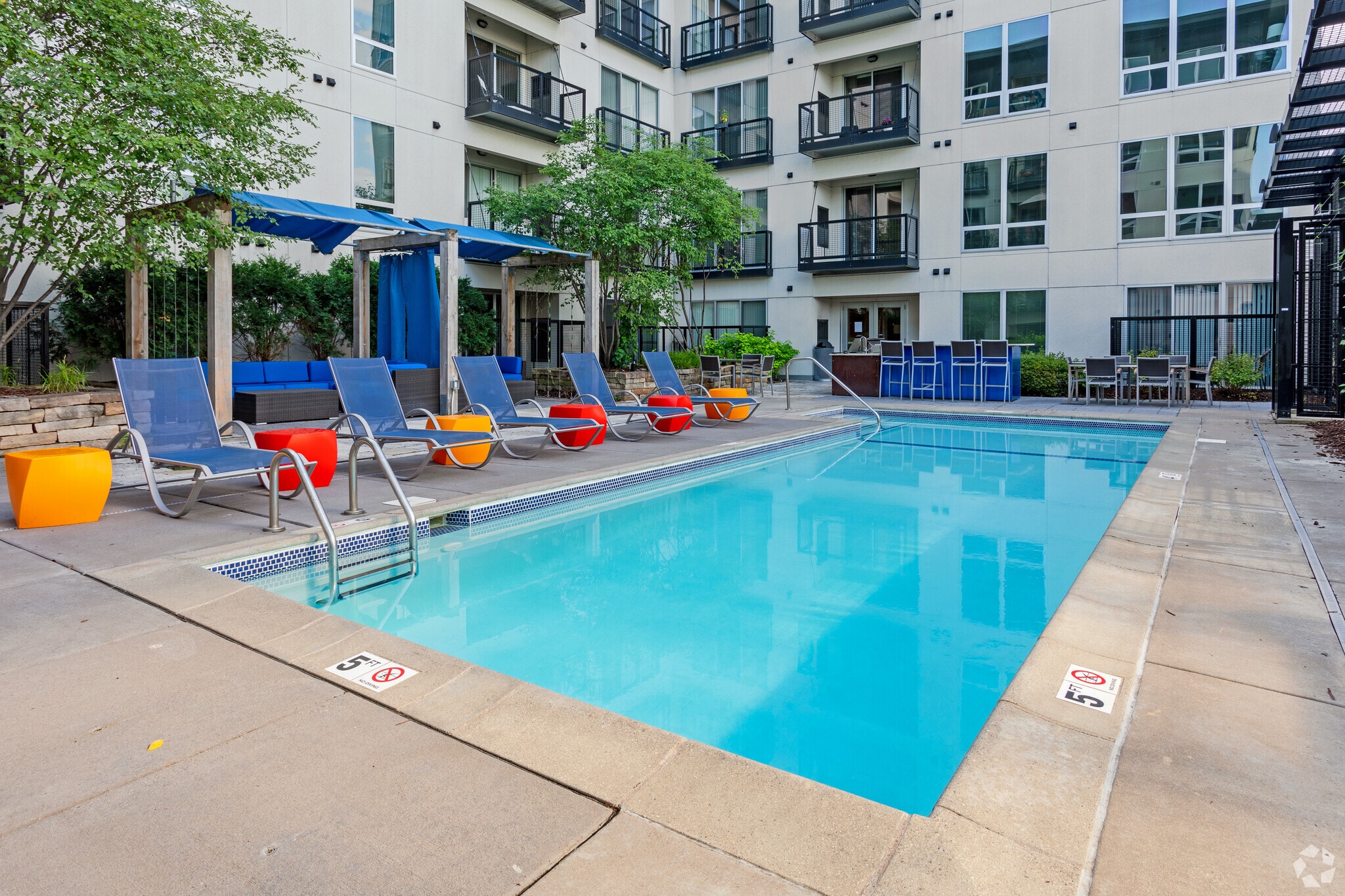 Outdoor swimming pool with lounge chairs and cabana.