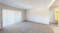 Located at 46 Brittany Farms Rd in New Britain, CT, this one-bedroom, one-bathroom unit offers a practical and well-arranged single-floor layout. The living area features neutral-toned wall-to-wall carpeting, a textured ceiling, and baseboard heating, with vertical blinds covering a large window that brings in natural light. The bedroom is generously sized, offering a comfortable retreat with carpeted flooring, additional windows with views of the surrounding community, and baseboard heating throughout. The kitchen is bright and functional, featuring white cabinetry, dark granite-style countertops, tile flooring, and a full suite of appliances including a gas range, refrigerator, dishwasher, and microwave. A chandelier adds a touch of warmth to the adjacent dining area. The bathroom is clean and efficiently designed, with tile flooring, a full tub-shower combination, a white vanity with storage, and a bright, neutral palette. A dedicated closet provides additional storage. The unit's overall aesthetic is clean and move-in ready, with a cohesive neutral color scheme throughout.