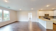Located at 41 W Prospect St in Waldwick, NJ, this thoughtfully designed single-floor residence offers a comfortable and modern living experience. The open-concept layout seamlessly connects the kitchen and living room, creating a bright and functional shared space bathed in natural light from large windows overlooking the surrounding neighborhood.

The kitchen is a standout feature, boasting crisp white shaker cabinetry, a light gray subway tile backsplash, quartz countertops, and a full suite of stainless steel appliances including a gas range, over-the-range microwave, and refrigerator. A peninsula with an undermount sink adds both prep space and a casual dining option.

The living area continues the clean aesthetic with smooth hardwood-style flooring and recessed lighting throughout. The generously sized primary bedroom features its own natural light through a large window and benefits from access to two closets, including a spacious walk-in outfitted with wire shelving systems for organized storage.

Both bathrooms are finished with neutral tile flooring and white vanities. The full bath includes floor-to-ceiling large-format stone-look tiles in the walk-in glass shower, while the second bath offers a clean, minimalist design. Consistent hardwood-style flooring and a neutral color palette throughout give the entire space a cohesive, contemporary feel.