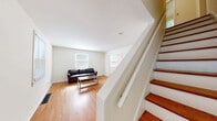 Located at 138 Grandview Ct in Ithaca, NY, this three-bedroom, one-bathroom residence spans three floors, offering a practical and functional layout throughout. The main level features warm hardwood flooring that runs through the living room, dining room, and connecting spaces. The living room is a comfortable, well-lit area with a window providing natural light. The adjacent dining room is similarly bright, with a window overlooking greenery and enough space for a full dining table and chairs. The kitchen is equipped with wood cabinetry, light countertops, a stainless steel sink, and standard appliances including a full-size refrigerator, set on tile flooring. An exterior door in the dining area provides convenient access to the outdoors. Upstairs, three bedrooms each feature hardwood floors and windows that bring in natural light with views of surrounding trees. The shared full bathroom includes a tub-shower combination and a window for natural ventilation. The lower level houses a utility room containing the mechanical systems, accessible via a staircase, offering additional storage potential. This home provides a straightforward, livable layout well-suited for Ithaca's residential neighborhood setting.