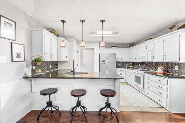 Kitchen featuring granite countertops, stainless steel fridge that is INCLUDED, and brand new backsp - 209 Prairie Wind Blvd