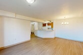 This one-bedroom, one-bathroom unit in Revere, MA offers a well-organized, single-floor layout with a clean, neutral aesthetic throughout. Light wood-tone flooring runs continuously across the main living areas, lending a bright and cohesive feel to the space.

The combined kitchen, dining, and living area forms the heart of the unit. The kitchen features warm oak-toned cabinetry, a curved peninsula with a light laminate countertop, a double sink, and a full suite of white appliances including a refrigerator, electric range, and microwave. A chandelier over the dining area adds a decorative touch. The open layout allows the kitchen to connect seamlessly to the living room, which is filled with natural light from sliding glass doors that open onto a private balcony overlooking the surrounding neighborhood.

The bedroom is a comfortable, well-proportioned room with the same light flooring, access to the hallway, and an electrical panel discretely housed within. Two closets provide practical storage throughout the unit.

The bathroom is finished in crisp white, featuring a full soaking tub with an overhead shower and a clean surround. The overall design of the unit is straightforward and functional, with a light color palette that maximizes brightness throughout.