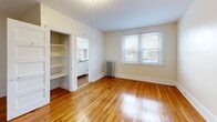 Located at 2 Copley Rd in Upper Darby, PA, this one-bedroom, one-bathroom unit offers a functional and well-organized layout across a single floor. Warm-toned hardwood floors run throughout the living spaces, lending a consistent and classic character to the interior.

The combined living and dining area provides an open feel, with natural light filtering in through double-pane windows that offer views of the surrounding neighborhood. A cast-iron radiator is present in the living area, reflecting the building's traditional heating system. The space includes a panel-style entry door and connects fluidly to the rest of the unit.

The bedroom is generously proportioned, accommodating a variety of furniture arrangements with ease. It features its own set of windows that bring in ample natural light, along with a radiator and access to closet space. Three closets are distributed throughout the unit, offering notable storage capacity.

The kitchen is efficiently laid out with light-toned cabinetry, tile backsplash, countertop space, and full-sized appliances including a refrigerator. The bathroom features a white vanity with a medicine cabinet mirror, a window for natural light and ventilation, a radiator, and wood-look flooring. Neutral wall tones throughout the unit create a clean, bright, and move-in ready atmosphere.