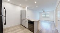 This 1-bedroom, 1-bathroom unit offers a clean, modern design across a single floor. The open-concept kitchen and living area forms the heart of the space, featuring light wood-look flooring, recessed lighting, and a ceiling fan that enhances airflow and comfort. The kitchen is equipped with gray cabinetry, granite-style countertops, a peninsula with a built-in sink, a dishwasher, a refrigerator, a range, and a microwave — providing ample functionality for everyday cooking and entertaining. The living area receives natural light through a window with blinds and includes access to an exterior door, adding a sense of openness to the layout.

The bedroom is carpeted for comfort and features a window overlooking the exterior, a ceiling fan, and sufficient space for standard furnishings. The full bathroom is accessible via the hallway and includes a vanity with storage, a toilet, and a shower/tub combination with shelving. Adjacent to the bathroom, a closet with wire shelving provides organized storage. The hallway connects all areas of the unit efficiently, contributing to a logical and easy-to-navigate floor plan. Throughout the unit, white walls and light-toned finishes create a bright, neutral aesthetic.