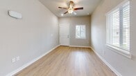 Located at 37136 Eiland Blvd in Zephyrhills, FL, this single-story 2-bedroom, 1-bathroom home offers a thoughtfully designed layout with modern finishes throughout. The open-concept living and kitchen area serves as the heart of the home, anchored by a central island with granite countertops and pendant lighting. The kitchen features white shaker cabinetry, a subway tile backsplash, stainless steel appliances including a refrigerator, range, microwave, and dishwasher, and light wood-style flooring that flows seamlessly into the living area. A ceiling fan and wall-mounted mini-split unit provide comfort throughout the main living space, which also benefits from natural light through blinds-fitted windows. The primary bedroom is a generously sized retreat with plush carpeting, multiple windows offering outdoor views, and its own mini-split unit for personalized climate control. The second bedroom features soft carpet flooring and a clean, neutral palette. Two closets provide ample storage throughout the home. The full bathroom includes a granite-topped vanity, a tub-shower combination, and wood-look tile flooring, rounding out this well-appointed and move-in ready residence.