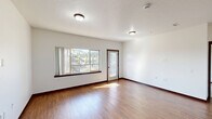 Located at 4116 W Hood River Ave in Spokane, WA, this single-floor, 2-bedroom, 2-bathroom residence offers a clean, modern design with a practical and comfortable layout. The open living area is highlighted by warm hardwood-style flooring, crisp white walls, and abundant natural light streaming through large windows that frame views of the surrounding neighborhood and mature trees. A glass-paneled door leads to a private balcony, extending the living space outdoors. The kitchen is well-equipped with rich dark wood cabinetry, granite-style countertops, stainless steel appliances including a refrigerator and range, and a built-in microwave — all set atop matching hardwood-style flooring. Both bedrooms are carpeted for comfort and feature windows that invite natural light and neighborhood views. The primary bedroom offers a generous footprint with dedicated closet space. The bathrooms are finished with tile flooring, wood vanities with stone-look countertops, and walk-in showers with grab bars. A dedicated in-unit laundry room includes a full-size washer and dryer with overhead shelving for added storage. Two closets throughout the unit provide ample organizational space, rounding out this well-designed Spokane residence.