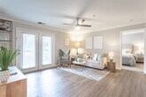 Located at 400 Eden Roc Cir in Virginia Beach, Virginia, this single-floor residence offers a well-designed layout that balances comfort and modern style. The living room serves as the heart of the home, featuring warm wood-look flooring, crown molding, a ceiling fan, and a set of French doors that invite natural light and provide outdoor access. The open, airy feel of the space is complemented by neutral gray tones on the walls.

The kitchen is outfitted with white shaker-style cabinetry, granite countertops, and a full suite of stainless steel appliances, including a range, microwave, and dishwasher. The dining area adjacent to the kitchen offers a comfortable setting with crown molding and track lighting overhead.

The primary bedroom features plush carpeting, a walk-in closet, and a private en-suite bathroom with granite countertops and a shower. Additional bedrooms are equally well-appointed with soft carpeting, ample closet space, and warm, welcoming finishes. A second full bathroom with wood-look flooring and clean, neutral finishes serves the remaining rooms.

Throughout the home, a cohesive palette of soft grays, warm wood tones, and crisp white trim creates a bright and inviting ambiance suited to the coastal Virginia Beach setting.