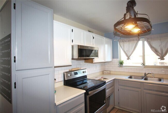 Kitchen with lots of cabinets and natural light. Newer stainless range and microwave - 3656 S Depew St