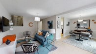 Located at 1355 Graves Rd in Norcross, GA, this two-story apartment offers a thoughtfully designed layout across two levels. The main living area is bright and open, finished with light tile flooring and neutral gray walls that create a clean, contemporary backdrop. A pendant light anchors the living space, which flows naturally into a dedicated dining area featuring a large sliding glass door that invites abundant natural light. The kitchen is well-appointed with white shaker-style cabinetry, granite countertops, a classic subway tile backsplash, and black appliances including a range and dishwasher. A bathroom on the upper level features white vanity cabinetry with granite countertops and wood-look flooring, complemented by a tub-shower combination. The bedroom is a comfortable, carpeted retreat with warm neutral tones and ample space. The dollhouse view reveals a well-organized multi-room floor plan that makes efficient use of space across both levels. Throughout the home, consistent finishes and modern touches provide a cohesive and inviting atmosphere suited for everyday living in the Norcross, GA area.