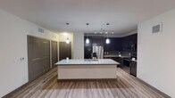 Located at 961 N Day Miar Rd in Grand Prairie, Texas, this single-story residence offers a contemporary design with thoughtfully appointed finishes throughout. The open-concept kitchen serves as the focal point of the main living area, showcasing rich dark espresso cabinetry that extends to the ceiling, providing generous storage. A large central island with a granite countertop and integrated sink anchors the space, illuminated by stylish pendant lighting. A gray subway tile backsplash complements the stainless steel appliances, including a French door refrigerator with water dispenser, electric range, and built-in microwave. Track lighting over the kitchen adds additional functionality. Light wood-look plank flooring runs throughout the main living areas, creating a warm, cohesive aesthetic.

The bedrooms are carpeted and feature ceiling fans and windows that allow natural light to filter in. The primary bathroom is well-appointed with a dual-sink vanity featuring granite countertops, dark cabinetry, wood-look flooring, a soaking tub, and a tiled shower surround. Generous walk-in closets with built-in shelving and hanging rods offer ample storage for each bedroom, completing this well-designed residence.