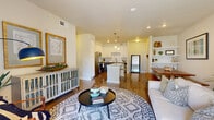 This single-story, 1-bedroom, 1-bathroom residence offers a thoughtfully designed open-concept layout that maximizes its efficient footprint. The living area is bright and welcoming, featuring warm hardwood-style flooring, neutral walls, and ample natural light streaming through large windows with white blinds. The space flows seamlessly into the kitchen and dining areas, creating an ideal environment for both daily living and entertaining.

The kitchen is a functional highlight, equipped with stainless steel appliances including a refrigerator, range, microwave, and dishwasher. White upper cabinetry contrasts elegantly with gray lower cabinets, while a granite-topped island provides additional prep space and seating. A subway tile backsplash adds a clean, modern touch.

The bedroom is a comfortable retreat with plush carpeting, generous natural light from double windows, a ceiling fan, and access to a walk-in closet. The bathroom features large-format tile flooring, a soaking tub with tile surround, and a gray vanity with granite countertops.

Additional spaces include a pantry, utility room, hallway, dining room, two closets, and a private patio. Recessed lighting throughout enhances the home's clean, contemporary aesthetic.