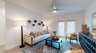 Located at 14976 Osprey Nest Loop in Lutz, Florida, this single-story residence offers a well-appointed, open-concept floor plan designed for comfortable everyday living. The living area is a welcoming space highlighted by soaring ceilings, a ceiling fan, and light wood-look flooring. A charming set of French doors fills the room with natural light, while the open layout creates a seamless sense of flow throughout the home. The kitchen is a standout feature, showcasing grey shaker-style cabinetry that extends to the ceiling for generous storage, a white subway tile backsplash, gleaming granite countertops, and a full suite of stainless steel appliances. A central island with bar seating provides an ideal spot for casual dining or entertaining. The bedroom offers a tranquil retreat, featuring plush carpeting, soft blue-toned walls, and a bright window dressed with sheer curtains that invite soft natural light. The bathroom is finished with a granite-topped vanity, wood-look tile flooring, and a full tub and shower combination with clean white tile surround. Throughout the home, consistent finishes and a light, neutral palette create a cohesive and inviting atmosphere well-suited for modern living in the heart of Hillsborough County.
