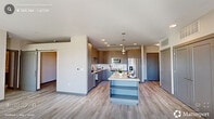 Located at 1005 West Main Street in Durham, NC, this modern 3-bedroom, 2-bathroom residence offers a well-designed single-floor layout with contemporary finishes throughout. The open-concept living, dining, and kitchen area serves as the heart of the home, featuring light wood-look flooring, recessed lighting, and large windows that invite natural light and offer views of the surrounding cityscape. The kitchen is a standout, boasting a generous central island with quartz countertops, taupe flat-front cabinetry with gold hardware, subway tile backsplash, stainless steel appliances including a French door refrigerator and range, and stylish pendant lighting overhead. The living area provides direct access to an outdoor balcony through a glass-paneled door. Each bedroom is bright and well-proportioned, with large windows, ceiling fans, and light wood-look flooring. The spacious primary bedroom connects to a well-appointed en-suite bathroom featuring a double vanity, large framed mirror, tiled walk-in shower, and an organized walk-in closet. A second full bathroom mirrors this clean, modern aesthetic. Additional conveniences include a laundry area, utility room, and four closets, rounding out a practical and polished living space.